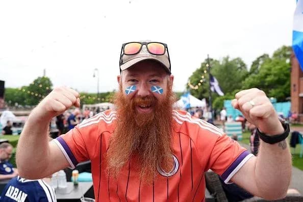 Hincha con barba y camiseta animando en evento