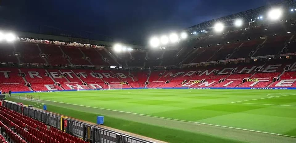 Estadio Old Trafford con asientos y césped visible