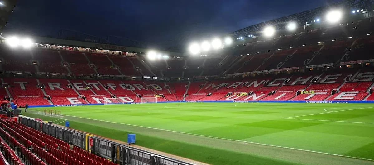 Estadio Old Trafford con asientos y césped visible
