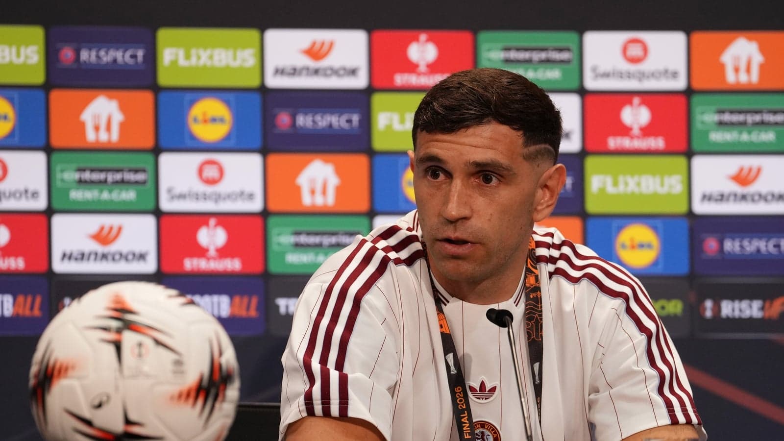 Jugador en rueda de prensa con balón frente a él