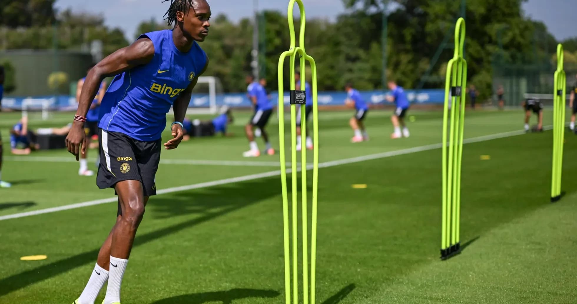 Jugador entrenando con conos en el campo