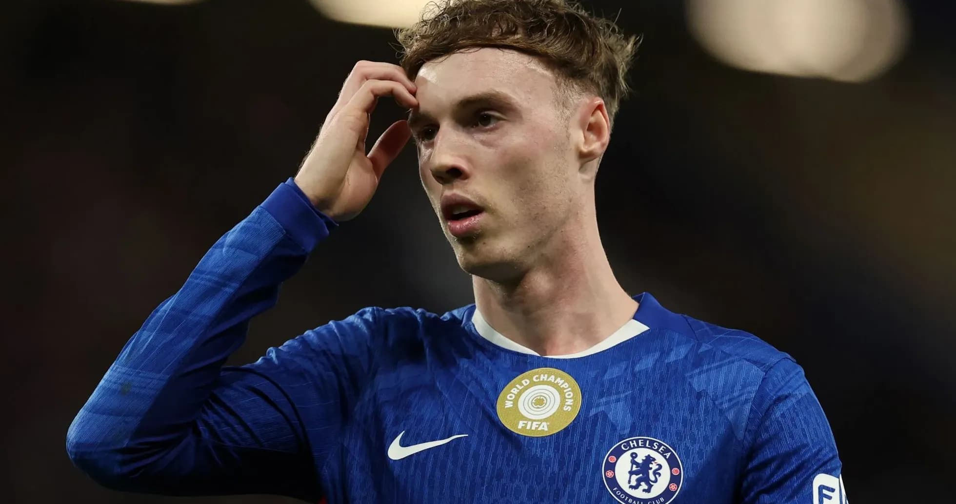 Jugador de Chelsea tocándose la cabeza en el campo