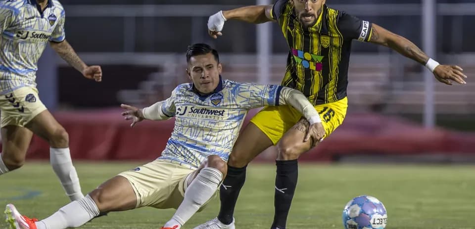 Jugador de New Mexico United desafiando a oponente