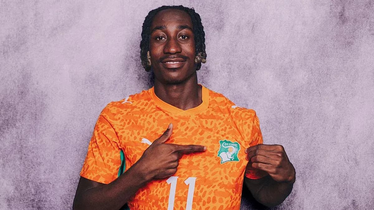 Jugador con camiseta naranja señalando el escudo de Côte d'Ivoire