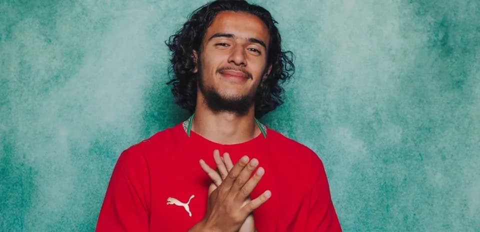 Jugador posando con camiseta roja y manos juntas
