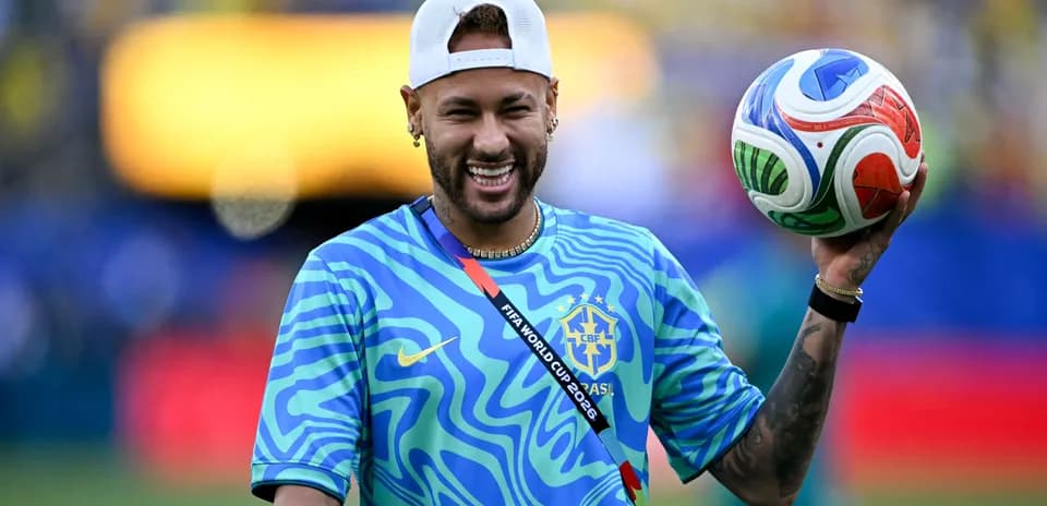 Neymar sosteniendo un balón en el campo