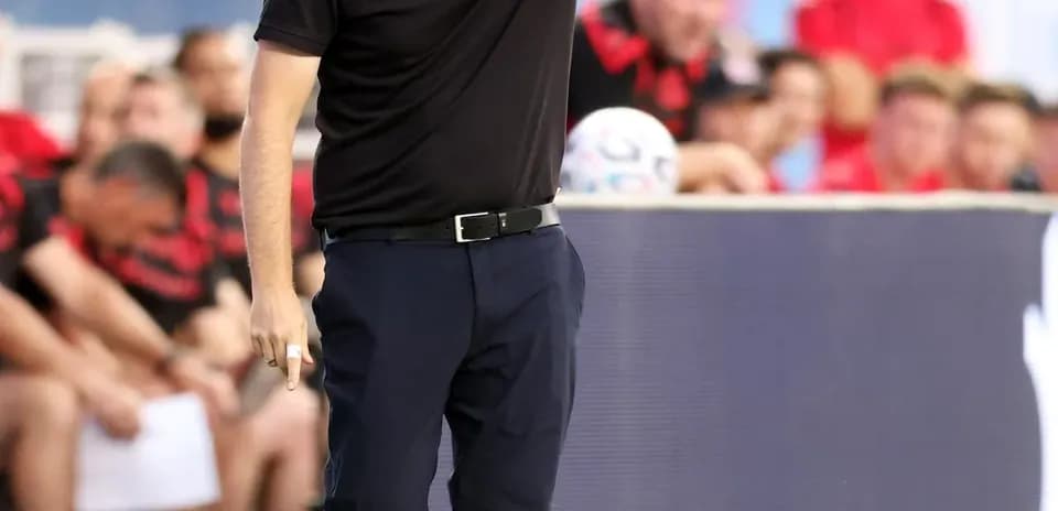 Entrenador dirigiendo desde la línea de banda