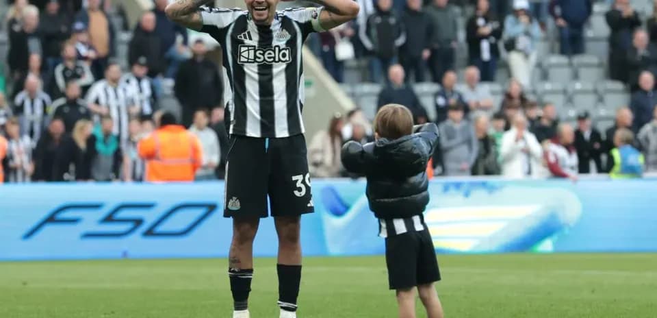 Jugador de Newcastle celebra con un niño en el campo