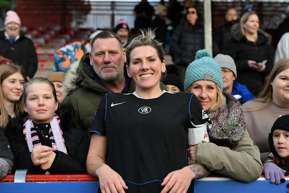 Jugadora sonriendo con fans en el fondo