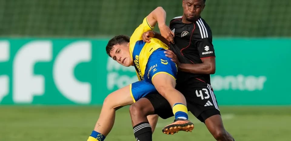 Jugador en disputa de balón durante partido de fútbol