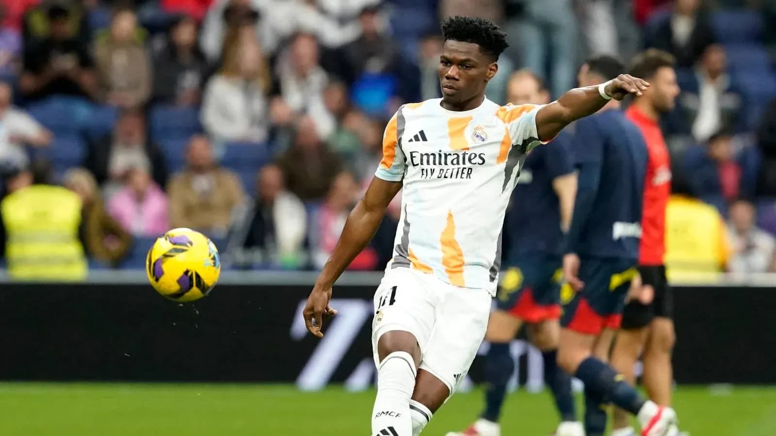 Jugador de Real Madrid lanzando el balón durante partido