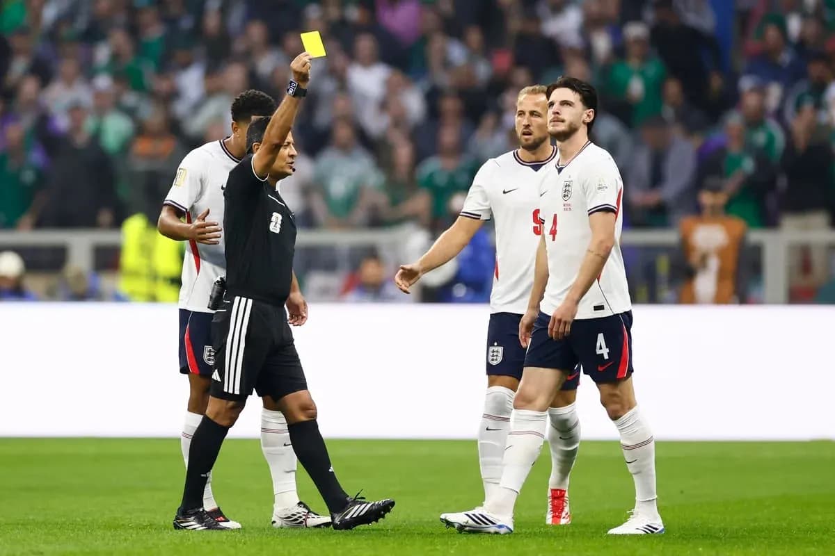 Árbitro mostrando tarjeta amarilla en partido de fútbol