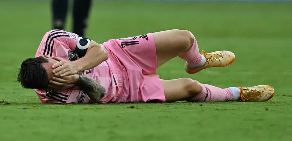 Jugador caído en el campo con camiseta rosa
