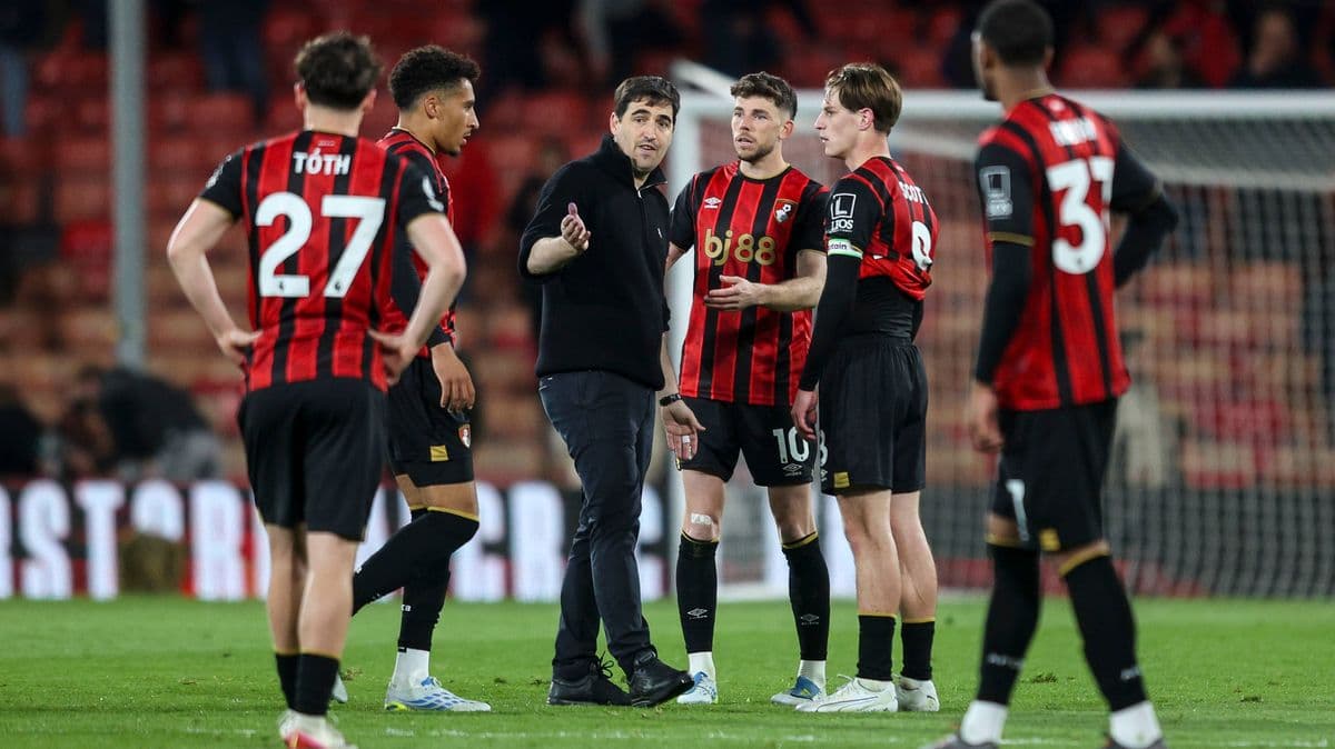 Entrenador hablando con jugadores de Bournemouth en el campo