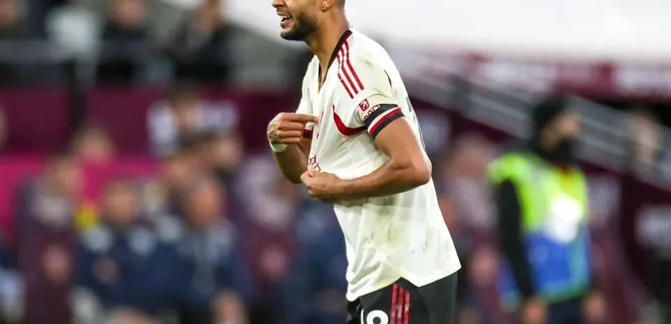 Jugador de fútbol señalando su camiseta en el campo