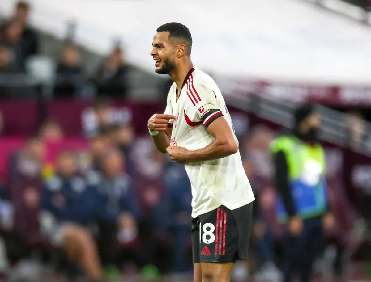 Jugador de fútbol señalando su camiseta en el campo