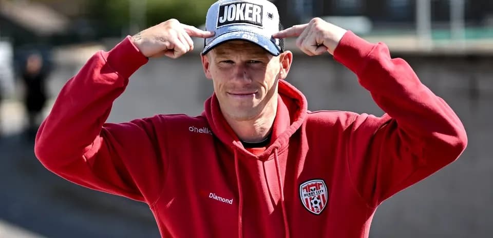 Hombre señalando su gorra con la palabra 'JOKER'