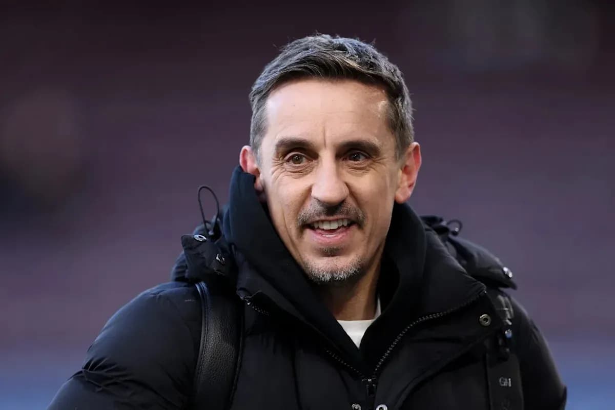 Hombre sonriendo con abrigo en estadio de fútbol