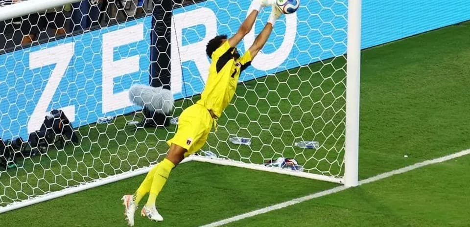 Portero lanzándose para detener un tiro a gol