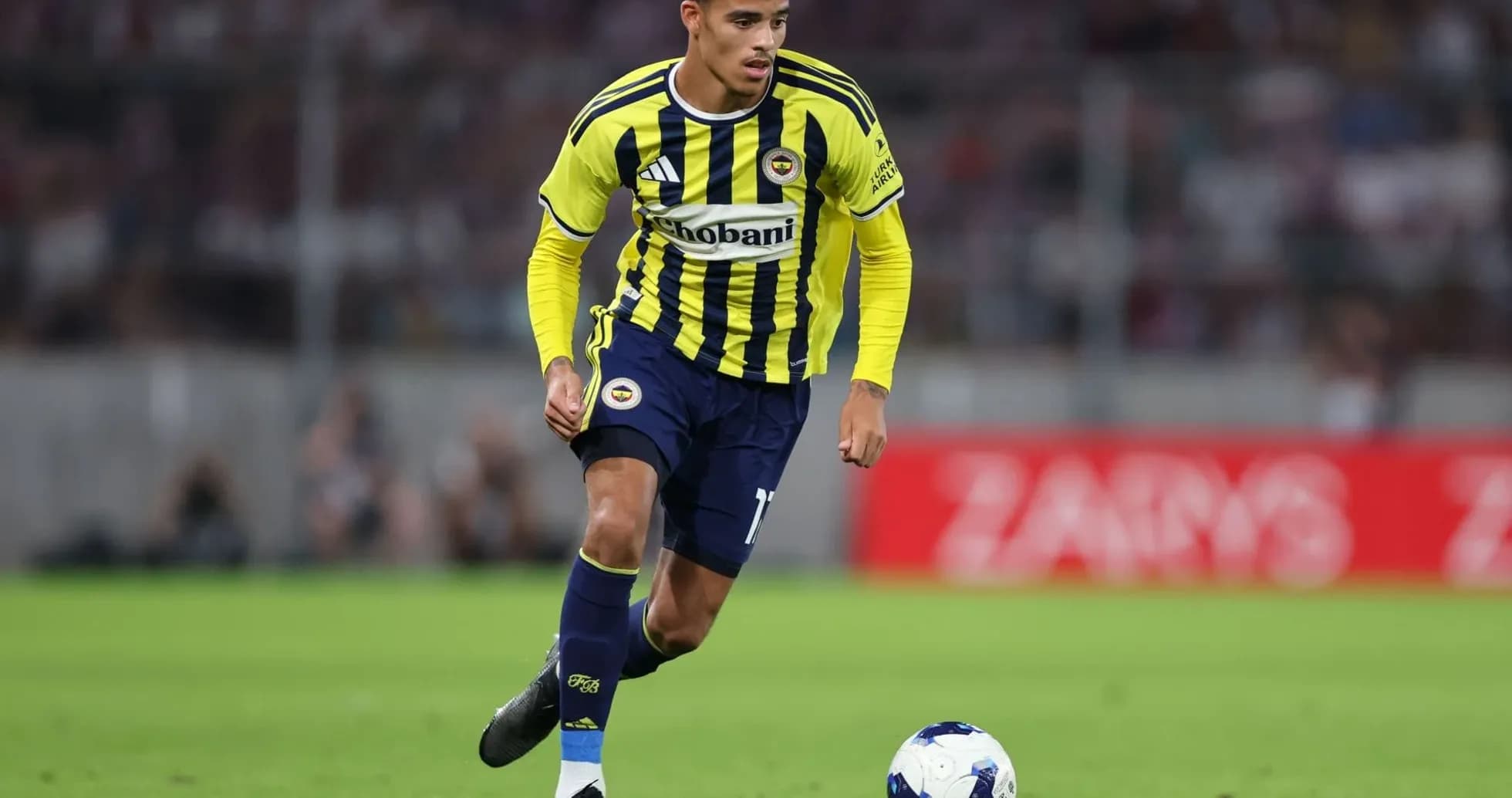 Jugador de Fenerbahçe corriendo con el balón