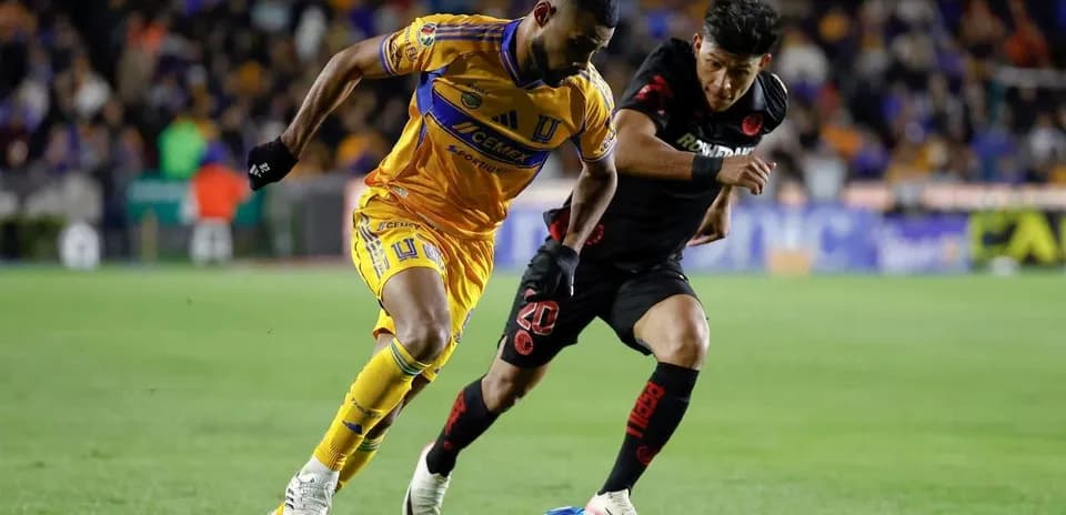 Jugadores de Toluca y Tigres luchando por el balón