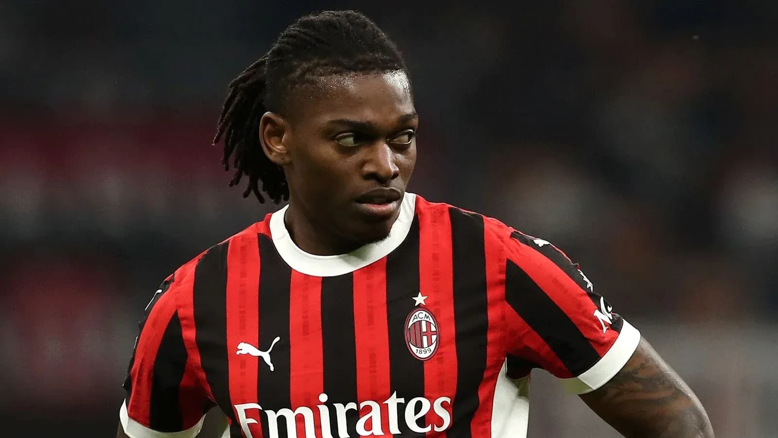 Jugador de AC Milan en uniforme con rayas rojas y negras