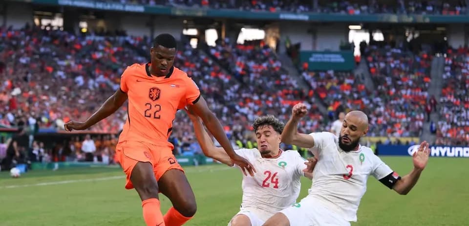 Jugador de Países Bajos esquivando a defensores marroquíes