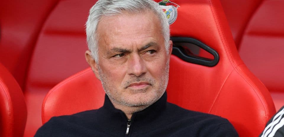 Entrenador sentado en banco con fondo rojo