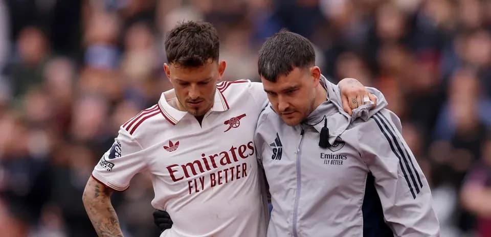Jugador de Arsenal siendo ayudado por personal médico