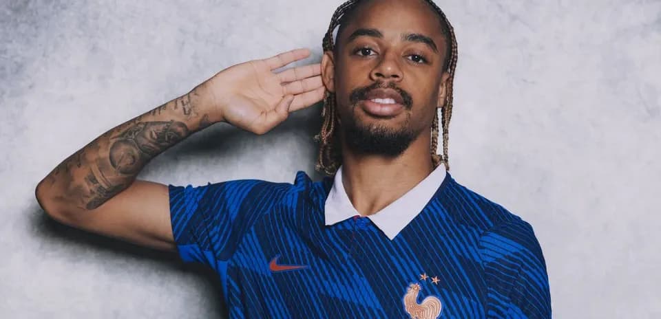 Jugador posando con camiseta de Francia y gesto de oído