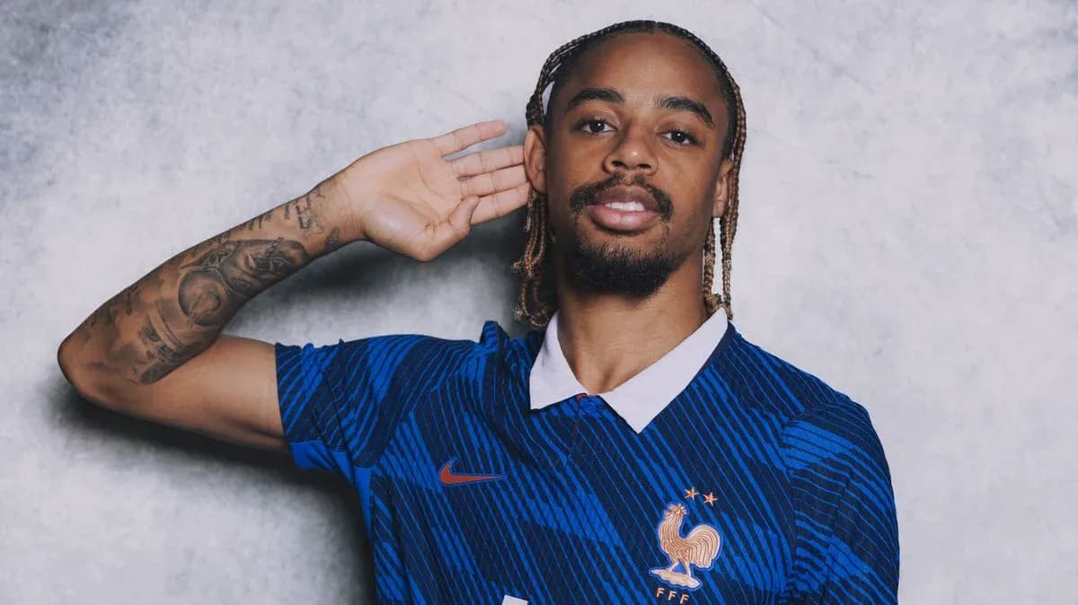 Jugador posando con camiseta de Francia y gesto de oído