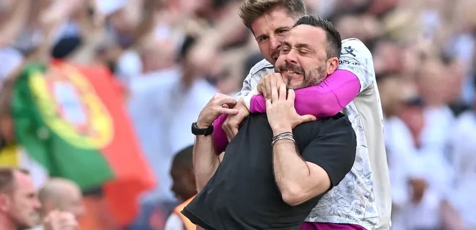 Dos entrenadores abrazándose en el campo de juego