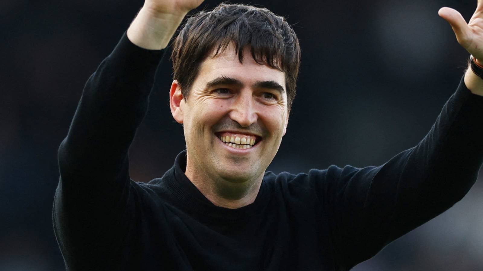 Entrenador sonriendo y saludando a la afición