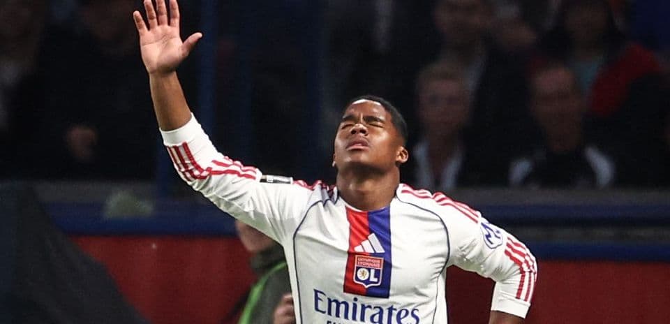 Jugador de Olympique de Lyon levantando la mano en el campo