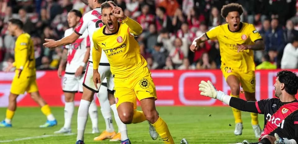 Jugador celebrando un gol mientras el portero reacciona
