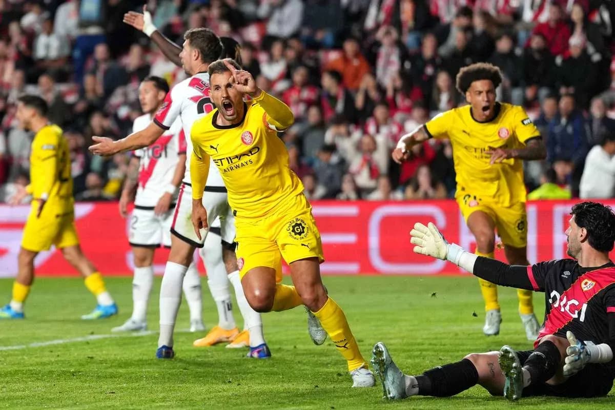 Jugador celebrando un gol mientras el portero reacciona