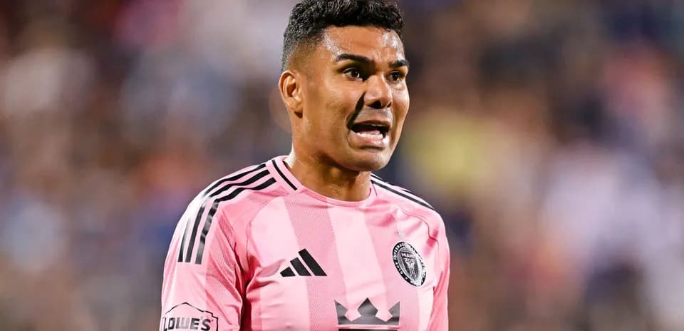 Jugador de fútbol en camiseta rosa hablando durante el partido
