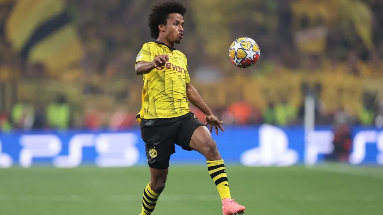Jugador de Borussia Dortmund controlando un balón en el campo Jugador de Borussia Dortmund controlando un balón en el campo
