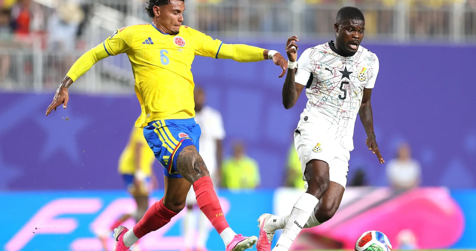 Jugador colombiano persigue a jugador ghanés en el partido Jugador colombiano persigue a jugador ghanés en el partido
