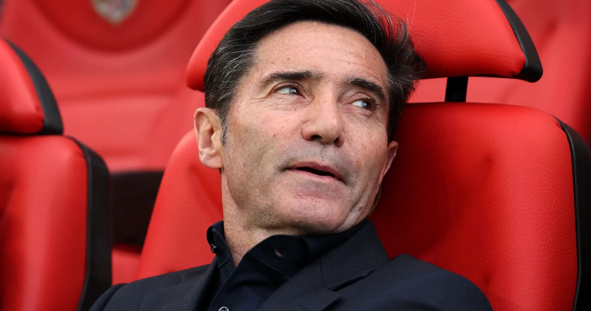 Entrenador sentado en banco durante el partido Entrenador sentado en banco durante el partido