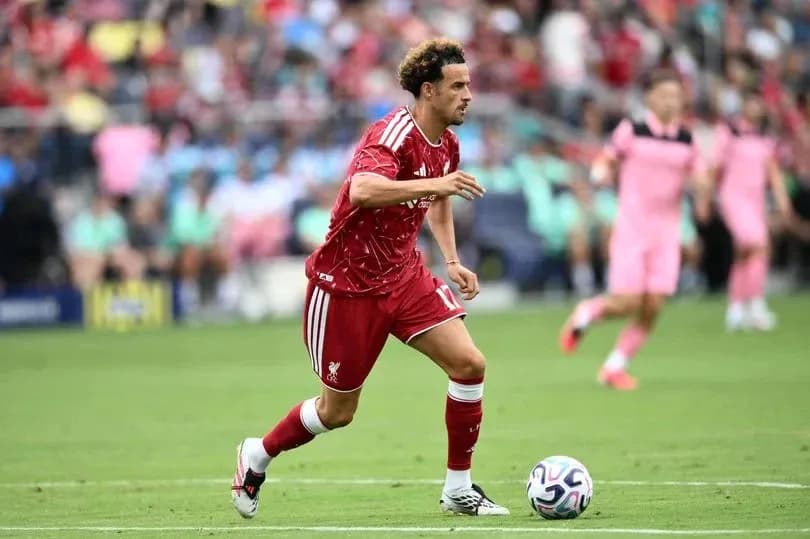 Jugador de Liverpool corriendo con el balón en el campo Jugador de Liverpool corriendo con el balón en el campo