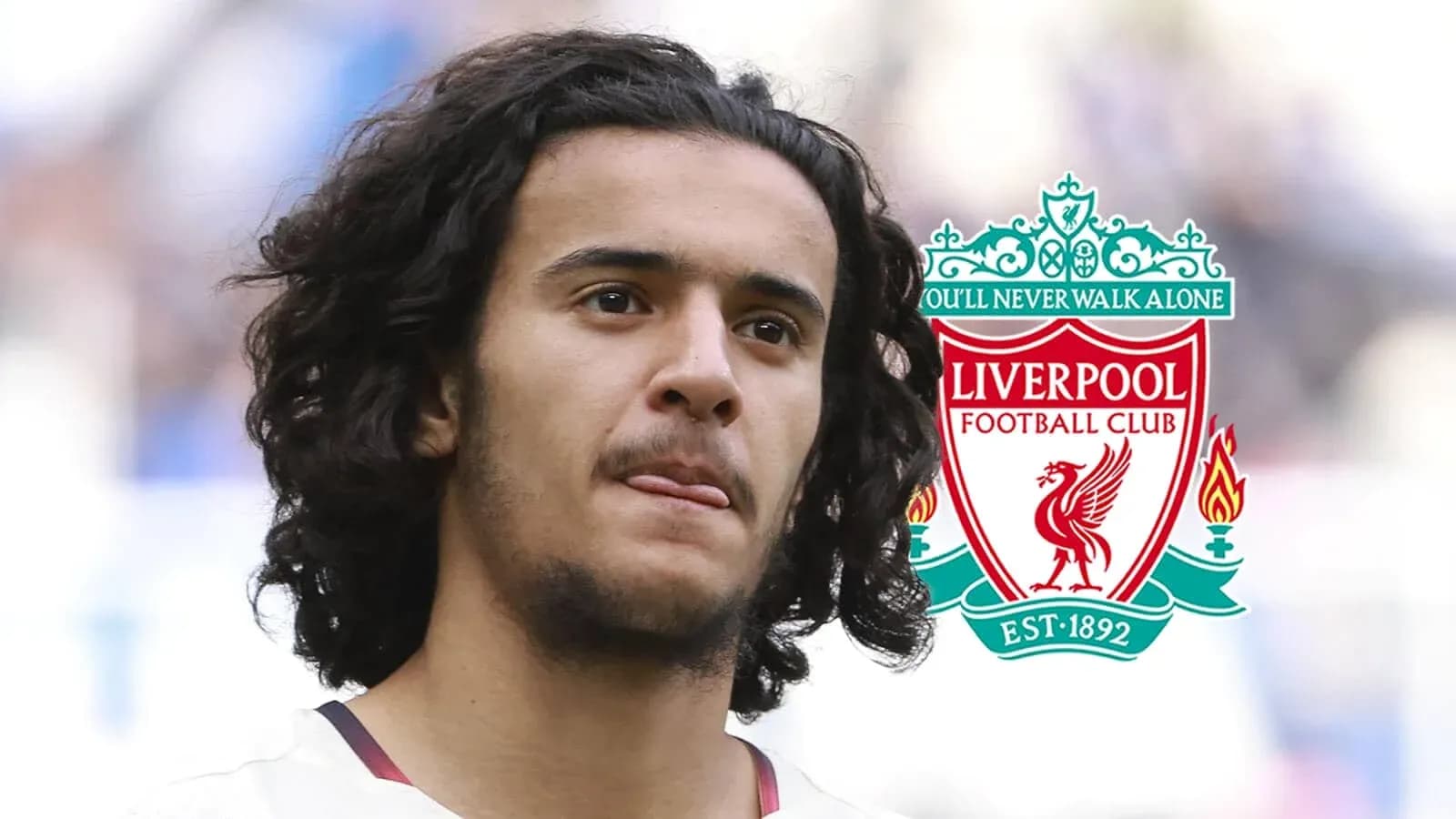 Jugador de Liverpool con el escudo del club Jugador de Liverpool con el escudo del club