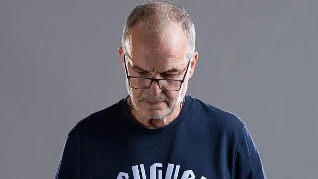 Hombre con gafas mirando hacia abajo, fondo gris Hombre con gafas mirando hacia abajo, fondo gris