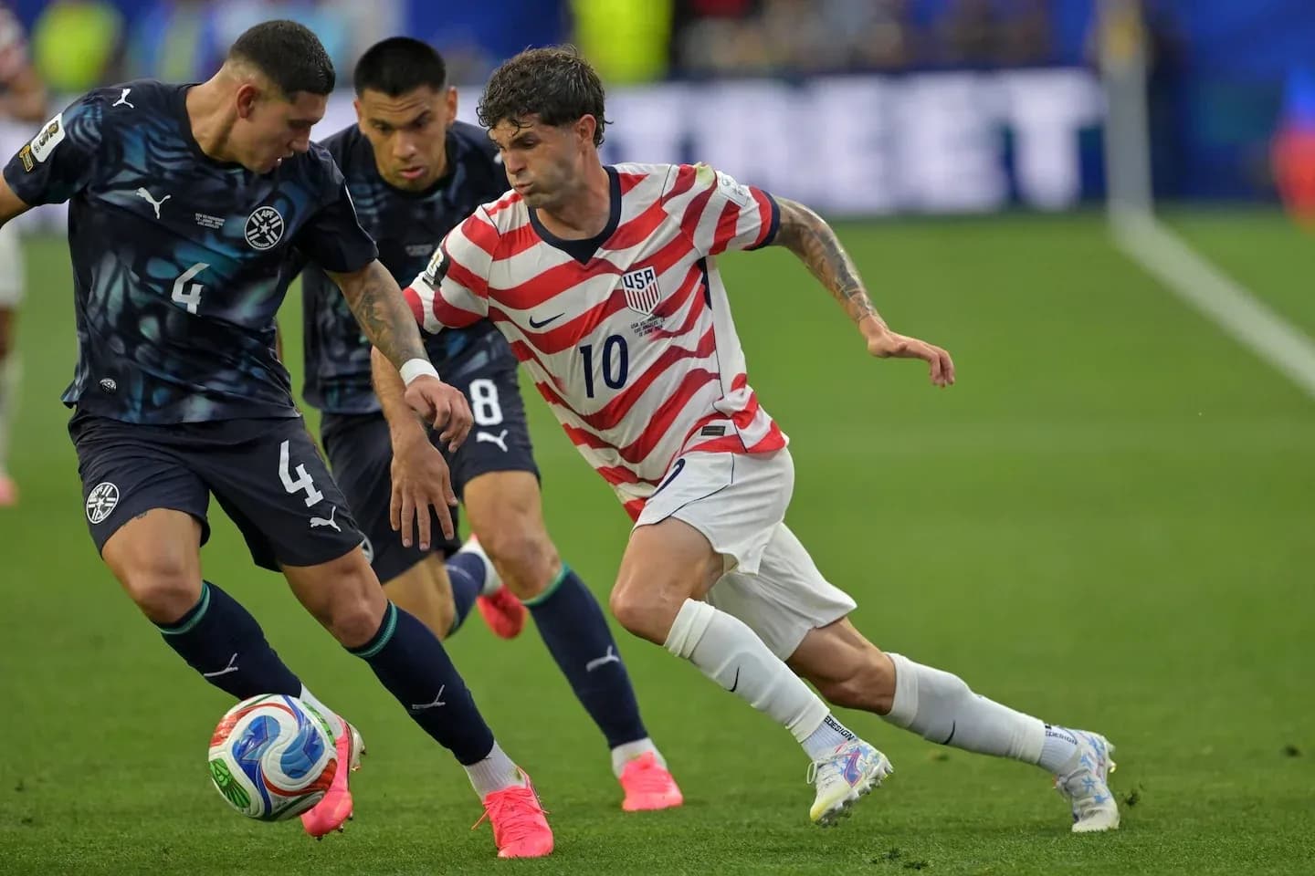 Christian Pulisic dribbling past Paraguay defenders Christian Pulisic dribbling past Paraguay defenders