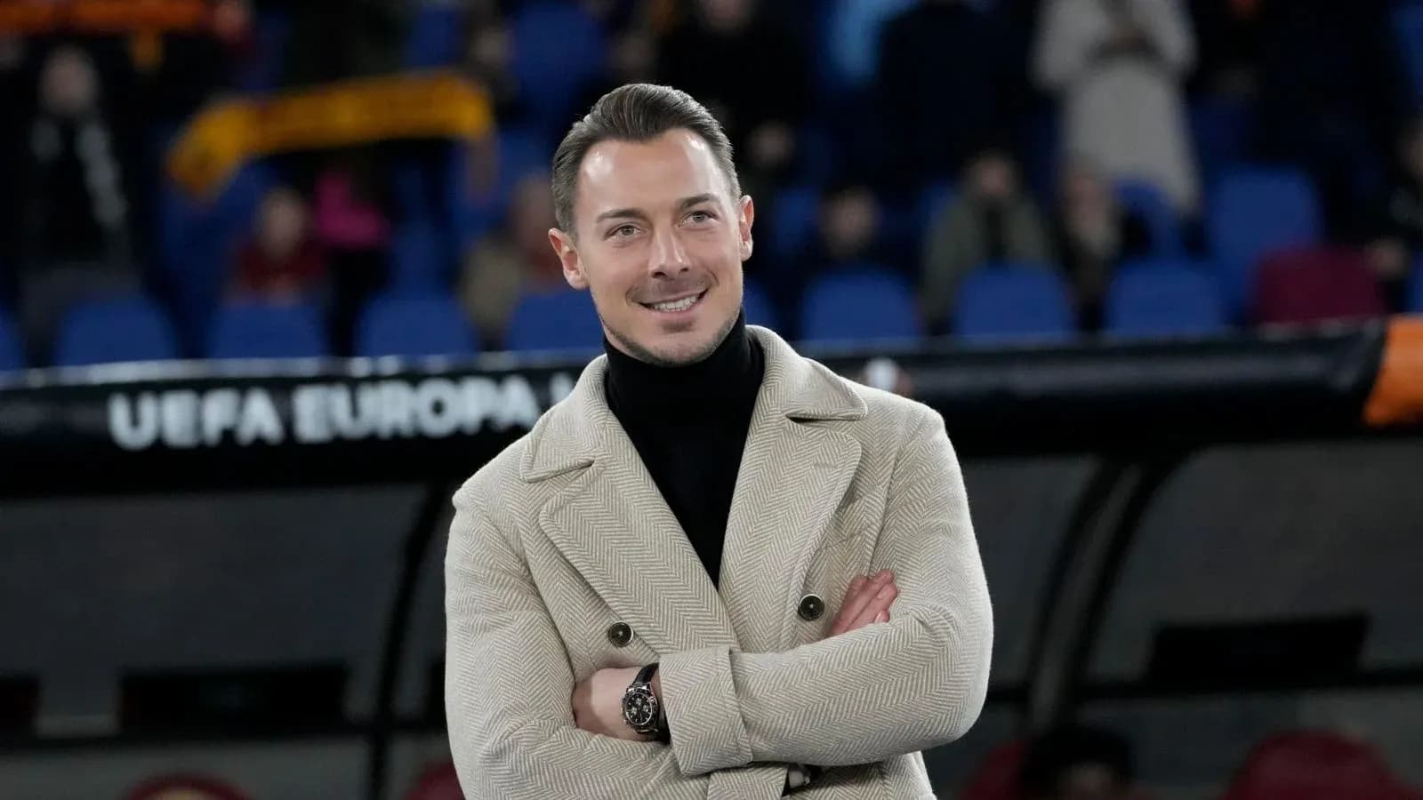 Hombre sonriendo con abrigo en estadio de fútbol Hombre sonriendo con abrigo en estadio de fútbol