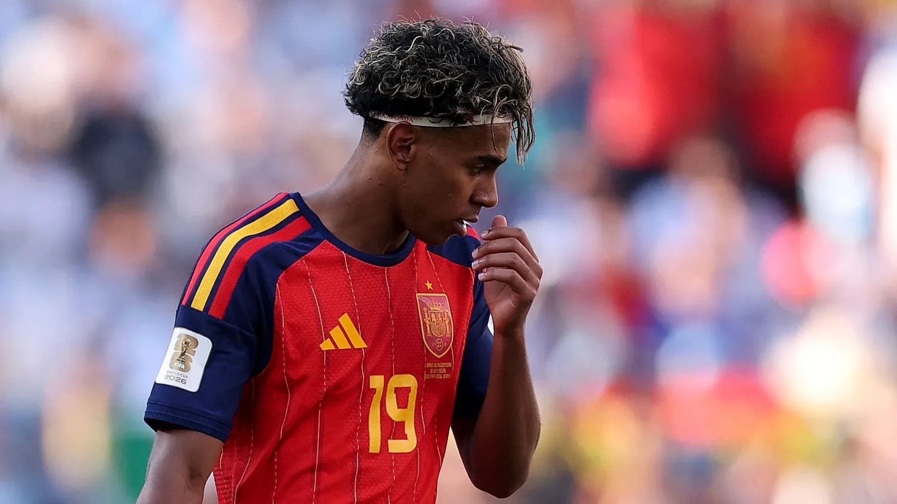 Jugador de España con camiseta roja, mirando hacia abajo Jugador de España con camiseta roja, mirando hacia abajo